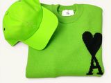 neon green sweater with black heart and hat on white background