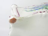 a white vase with a floral design on it