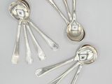 three silver spoons and two silver spoons on a white surface