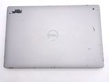dell laptop computer sitting on top of a white table with a dell logo on it