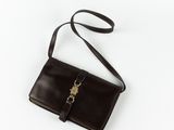 a brown leather purse with a metal clasp on a white background