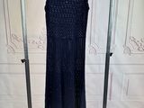 black beaded dress hanging on a clothes rack in a room