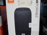 une photo d'un carton contenant une enceinte, posé sur une étagère dans un magasin
