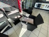 une chaise en osier noir et une table blanche dans une pièce