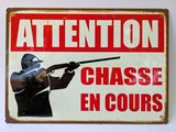 un panneau indiquant « Attention, chasse en cours »