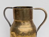 a metal pitcher with a handle on a table