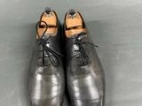 pair of men ' s black leather shoes with laces on them