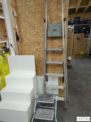 une échelle posée à côté de quelques cartons dans une pièce