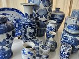 many blue and white vases and cups on the table