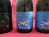 trois bouteilles de vin posées sur une table rose
