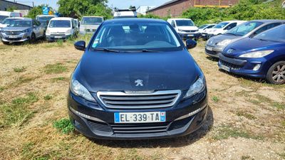 une voiture noire garée sur un parking, avec d'autres voitures en arrière-plan