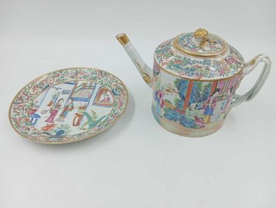 une théière et une assiette posées sur une table blanche