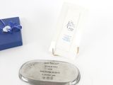 une boîte bleue ornée d'un ruban bleu et un plateau argenté orné d'un ruban bleu