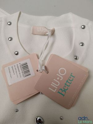 a white shirt with a tag on it and a tag attached to it