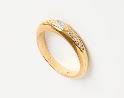 gros plan d'une bague en or sur une surface blanche