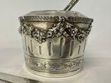 a silver cup with a spoon in it and a spoon in it
