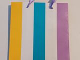 a paper bag with a purple ribbon on top of it
