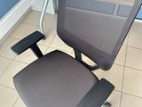 a black office chair sitting in front of a wooden desk