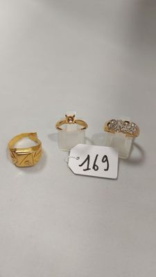 trois bagues en or et une bague en diamant posées sur un fond blanc