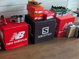 several pairs of new balance shoes sitting on top of boxes
