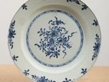 a blue and white plate with flowers on it on a table