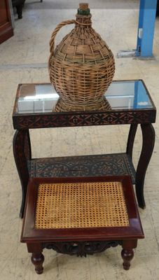 un panier en osier posé sur une petite table au plateau en verre