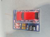 a red toy car in a package on a table