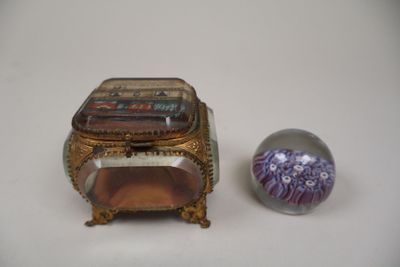 une petite boîte posée à côté d'une petite boule de verre