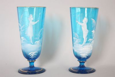 paire de vases en verre bleu ornés de motifs sur fond blanc