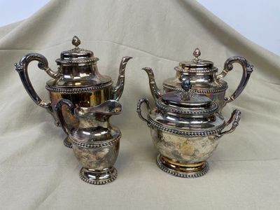 deux théières en argent posées sur une nappe blanche