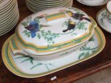 many plates and bowls on the table with a bird on them