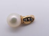 a close up of a pearl and diamond ring on a white surface