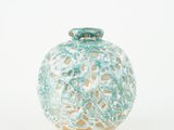 a small blue vase with holes in it on a white surface