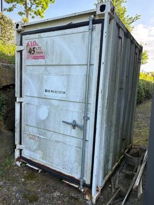 une vieille toilette extérieure au milieu d'un champ
