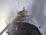a metal pot with a spoon on top of it