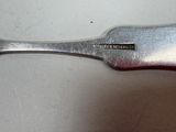 a silver spoon with a red handle sitting on a table