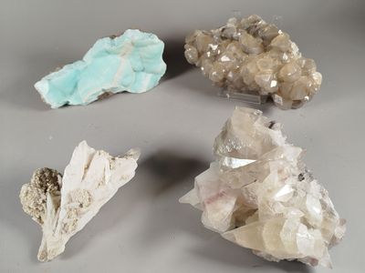 several different kinds of rocks and crystals on a gray surface