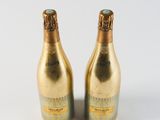 two bottles of champagne sitting next to each other on a white surface