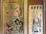 trois tableaux asiatiques accrochés au mur d'une pièce