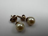 a pair of pearl earrings on a white surface