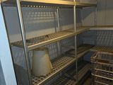a metal shelf with baskets on it in the corner of a room