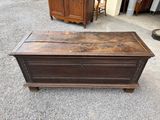 an old wooden chest sitting on top of a gravel floor