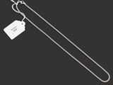 a silver chain with a tag attached to it on a black background