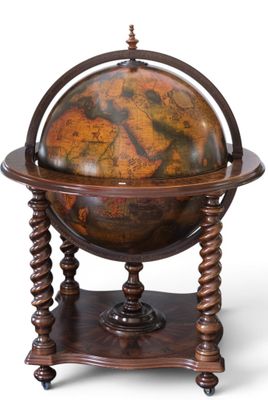un vieux globe terrestre posé sur un socle, sur fond blanc