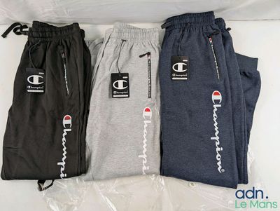 trois paires de pantalons de survêtement « Champion » posées sur un sac en plastique