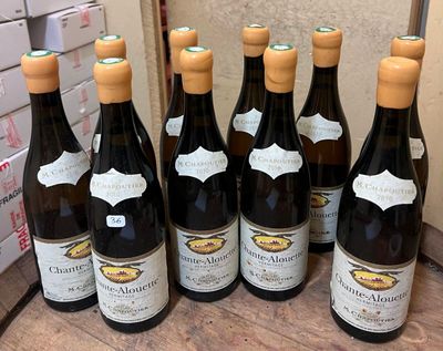 six bottles of wine are lined up on a wooden table