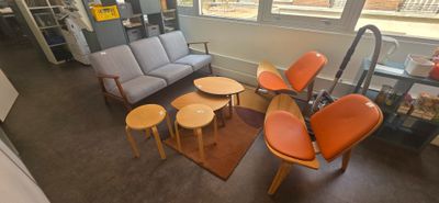 une photo d'un salon avec un canapé, des fauteuils et des tables