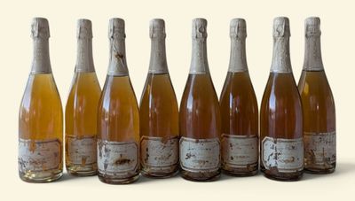 six bottles of wine are lined up in a row on a white surface