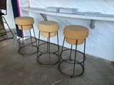 three stools are sitting in front of a counter in a room