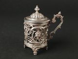 an antique silver teapot with a lid and handle on a black background